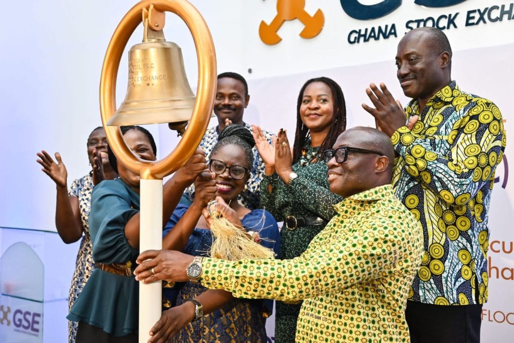 Group of people in Ghanaian clothes ring bell at stock exchange. Ghana Stock Exchange launches OTC market for trading equities, rural and community banks may raise capital