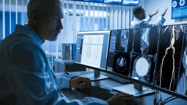 A man in white labcoat in front of medical imaging monitor. Medtech firm T2S is busy with a share offer on the Bourse de Casablanca.