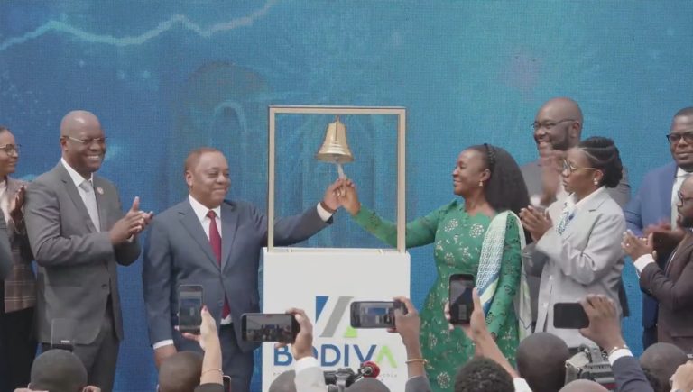 Crowd of people in formal dress ringing ceremonial bell to celebrate the listing of Unitel shares on the BODIVA, Angola's stock exchange